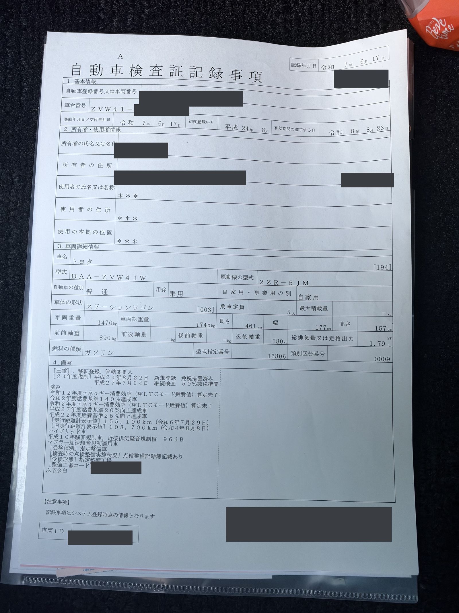 The inspection record sheet for a Toyota Prius α, with the registration number, most of the chassis number, the owner's name and address and the codes covered